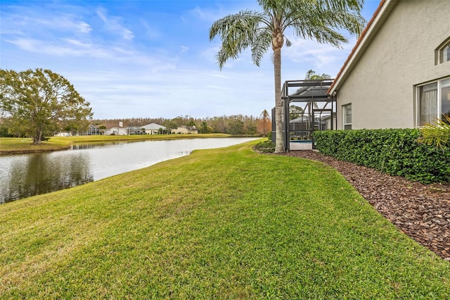 view of yard featuring a water view and glass enclosure