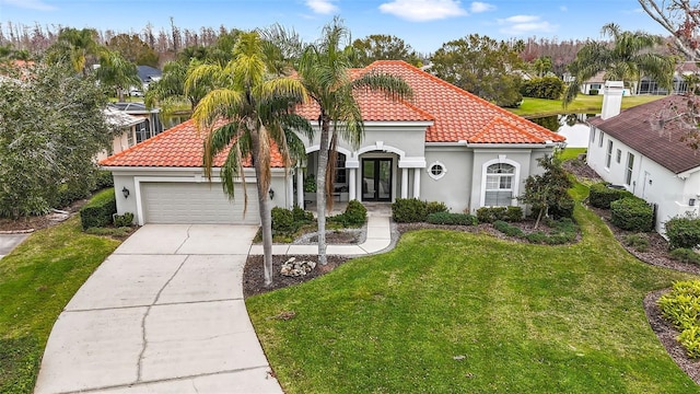 mediterranean / spanish-style house featuring french doors, a garage, and a front yard