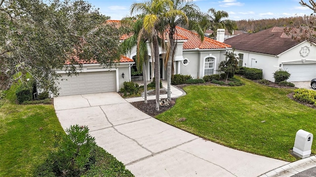 mediterranean / spanish house with a garage and a front yard