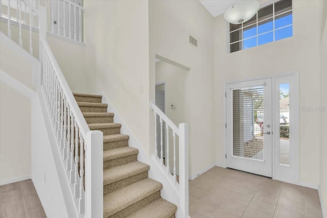 entryway featuring light tile patterned flooring and a high ceiling