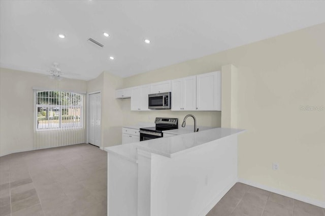 kitchen featuring kitchen peninsula, ceiling fan, appliances with stainless steel finishes, white cabinets, and sink