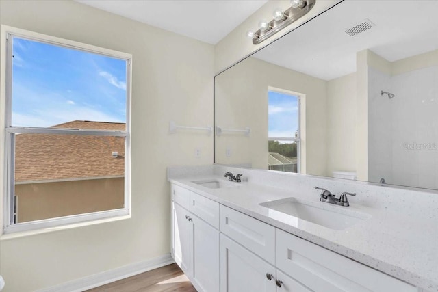 bathroom with toilet, vanity, walk in shower, and hardwood / wood-style flooring