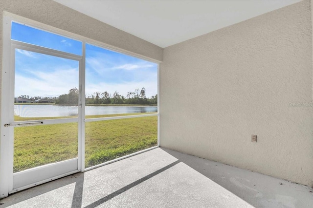 unfurnished sunroom featuring a water view