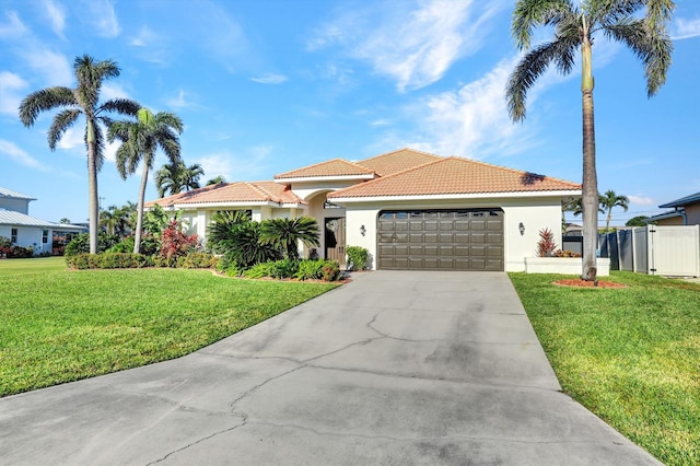 mediterranean / spanish-style house featuring a front yard and a garage