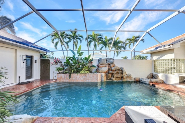 view of pool with glass enclosure and pool water feature