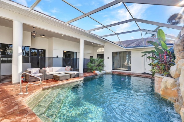 view of pool with pool water feature, glass enclosure, and a patio area