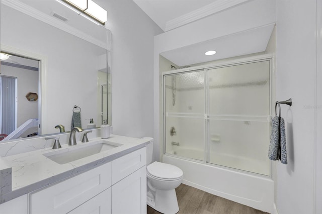 full bathroom with wood-type flooring, vanity, toilet, combined bath / shower with glass door, and crown molding