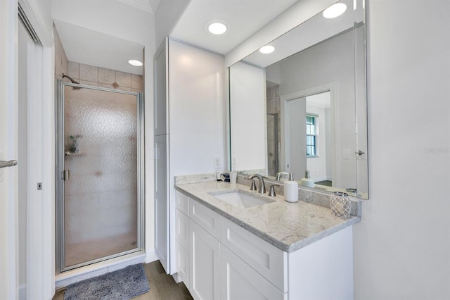 bathroom with vanity, a shower with door, and hardwood / wood-style flooring