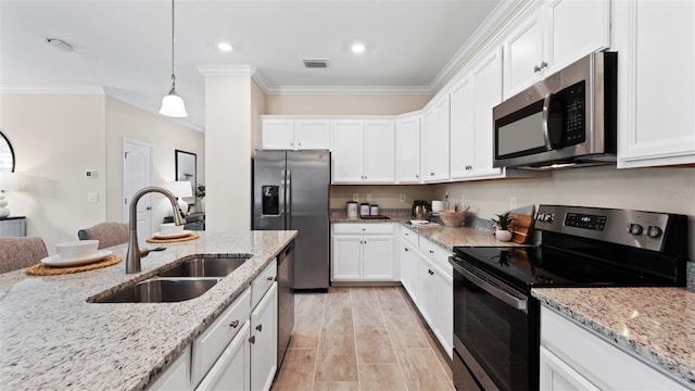 kitchen with pendant lighting, sink, white cabinetry, stainless steel appliances, and light stone countertops