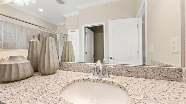 bathroom featuring ornamental molding, vanity, and a shower with shower door