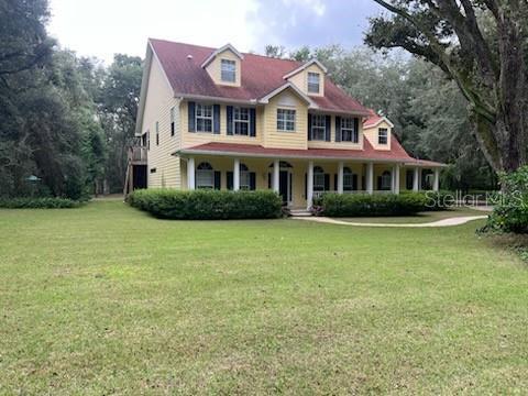 colonial inspired home featuring a front yard and a porch