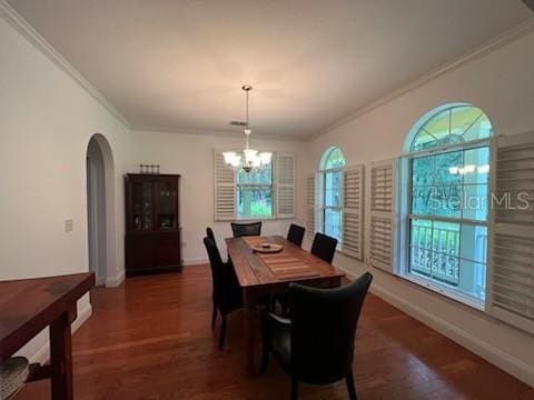 dining area with plenty of natural light, dark wood-type flooring, crown molding, and a notable chandelier