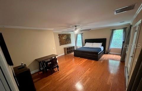 bedroom with ceiling fan, crown molding, and hardwood / wood-style floors