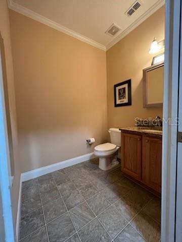 bathroom with toilet, vanity, and crown molding