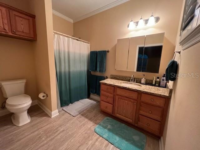 bathroom with toilet, crown molding, hardwood / wood-style floors, and vanity