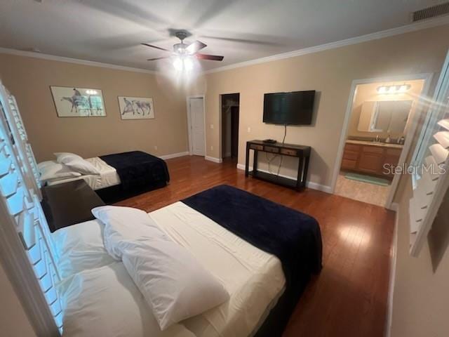 bedroom featuring ceiling fan, connected bathroom, hardwood / wood-style flooring, and ornamental molding