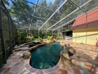 view of pool featuring glass enclosure and a patio area