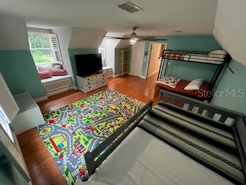 bedroom with ceiling fan, light hardwood / wood-style flooring, and vaulted ceiling