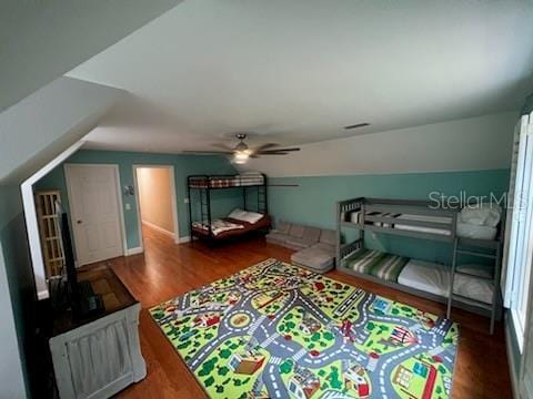 bedroom with ceiling fan, vaulted ceiling, and hardwood / wood-style flooring