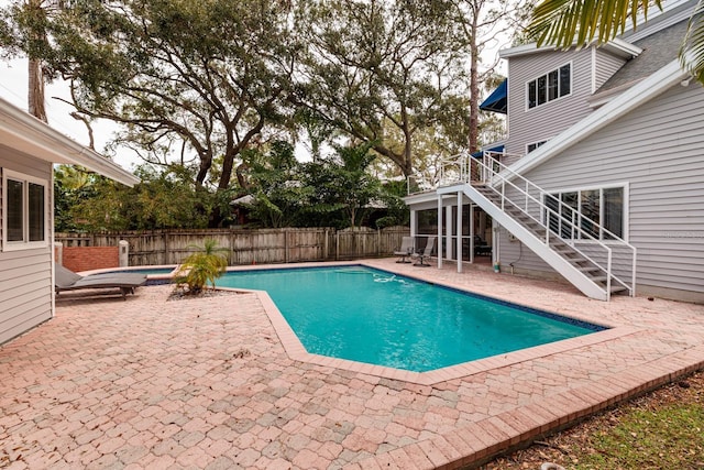 view of swimming pool featuring a patio area and a sunroom