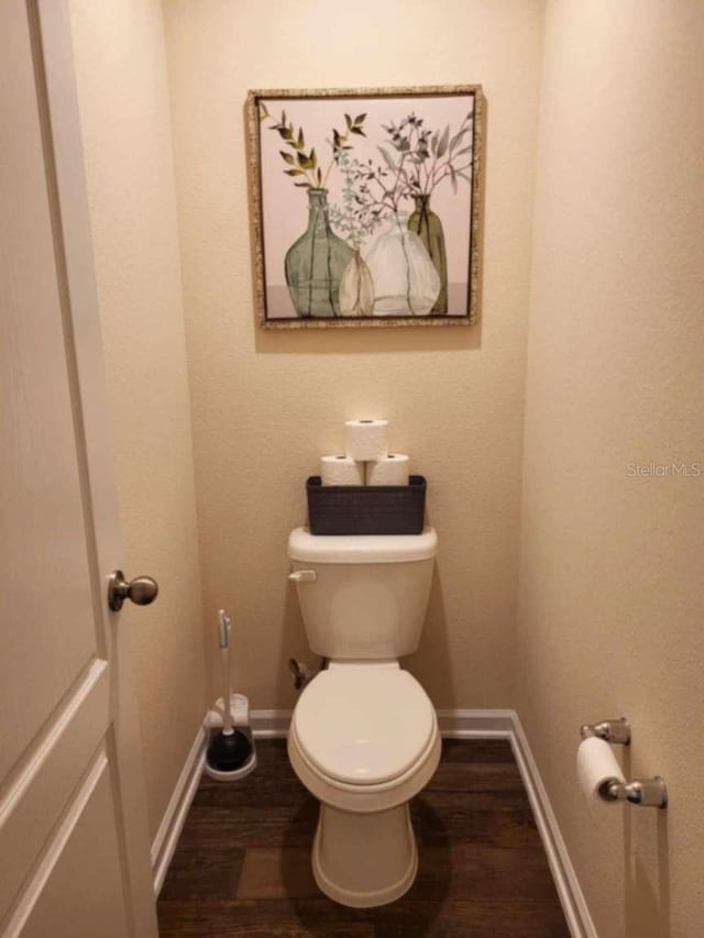 bathroom with toilet and hardwood / wood-style flooring