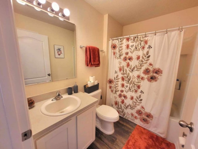 full bathroom with toilet, vanity, shower / bathtub combination with curtain, wood-type flooring, and a textured ceiling