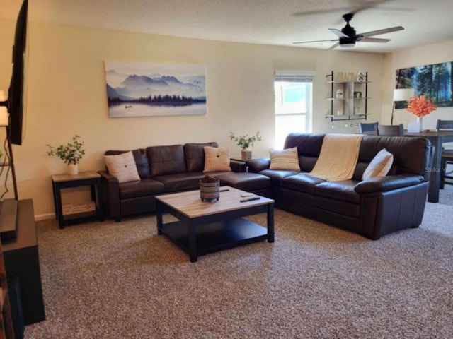 living room featuring carpet, ceiling fan, and a textured ceiling