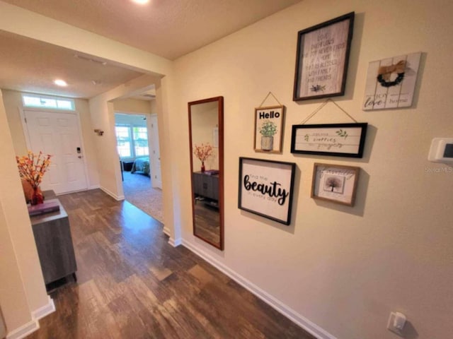 hall with dark hardwood / wood-style flooring and a textured ceiling