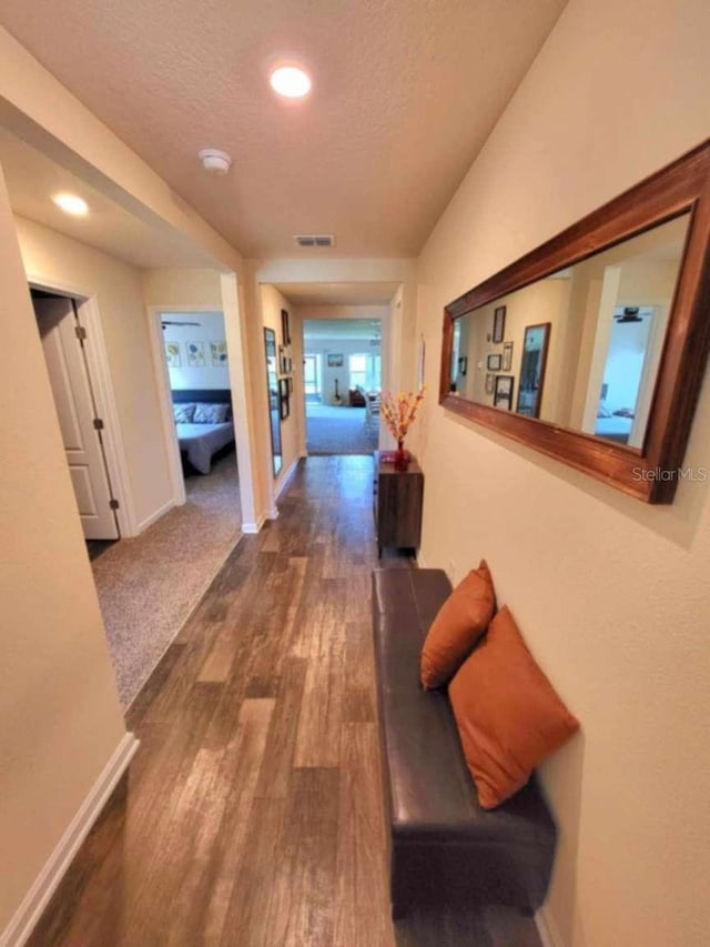 hallway featuring dark hardwood / wood-style flooring and a textured ceiling