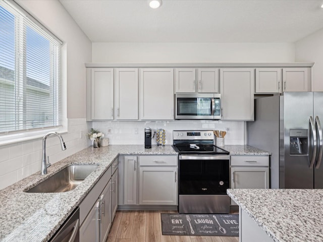 kitchen featuring plenty of natural light, sink, stainless steel appliances, and hardwood / wood-style floors