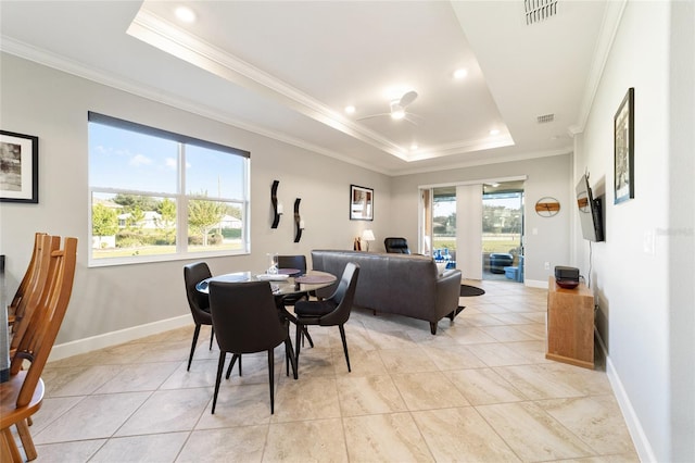 dining room with ceiling fan, crown molding, a raised ceiling, and light tile patterned flooring