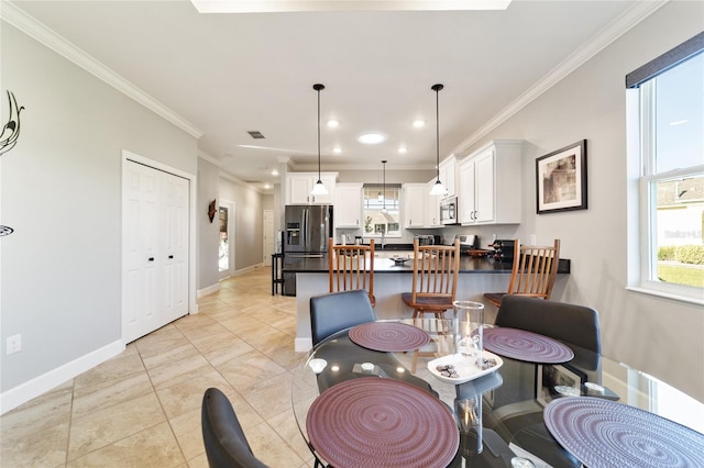 dining space with ornamental molding and light tile patterned flooring