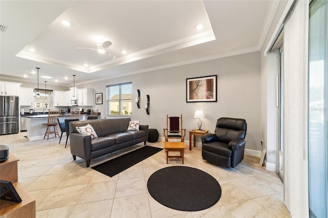 tiled living room with ceiling fan, crown molding, and a raised ceiling