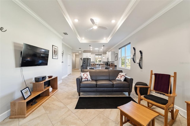 tiled living room featuring ceiling fan, ornamental molding, and a raised ceiling