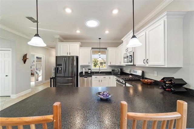 kitchen featuring white cabinetry, light tile patterned floors, hanging light fixtures, and appliances with stainless steel finishes