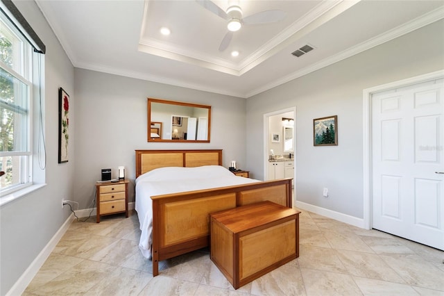 bedroom with crown molding, ensuite bath, ceiling fan, and a tray ceiling