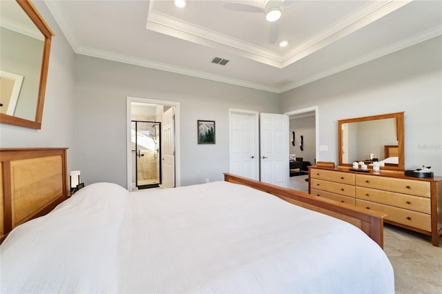 bedroom featuring ceiling fan, a raised ceiling, ornamental molding, and ensuite bath