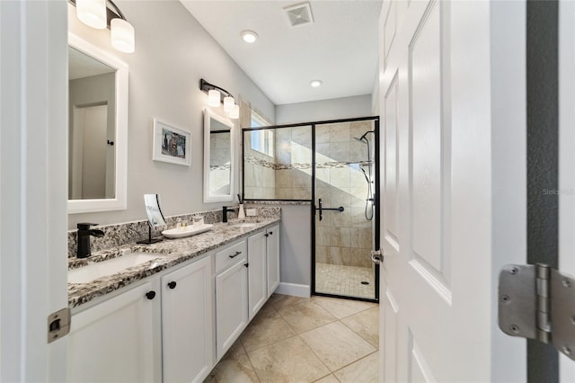 bathroom with vanity, an enclosed shower, and tile patterned flooring