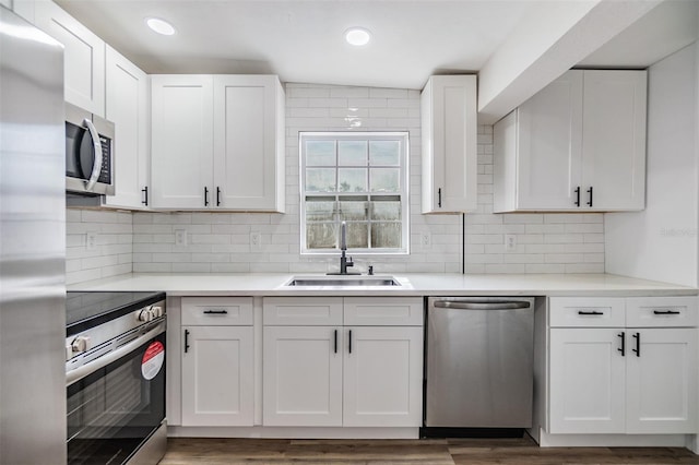 kitchen featuring dark wood-type flooring, sink, white cabinetry, tasteful backsplash, and stainless steel appliances