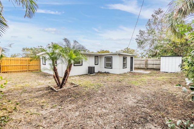 back of property with central AC and a storage unit