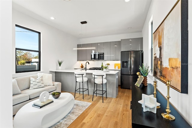 living room with light wood-type flooring and sink