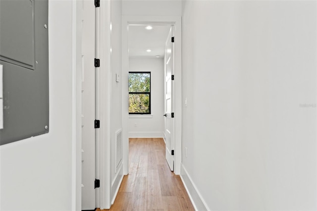 hall with electric panel and light hardwood / wood-style floors