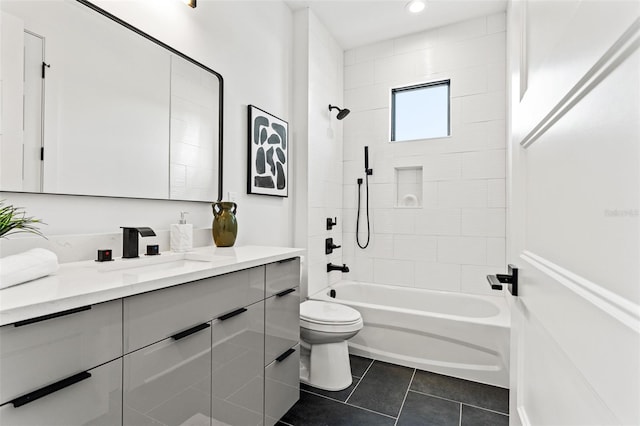 full bathroom featuring toilet, tile patterned floors, vanity, and tiled shower / bath