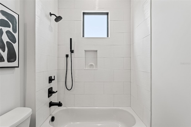 bathroom featuring toilet and tiled shower / bath combo