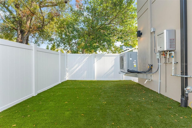 view of yard with tankless water heater and ac unit