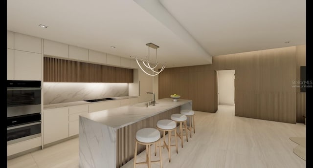 kitchen with a center island with sink, decorative light fixtures, black stovetop, white cabinets, and sink