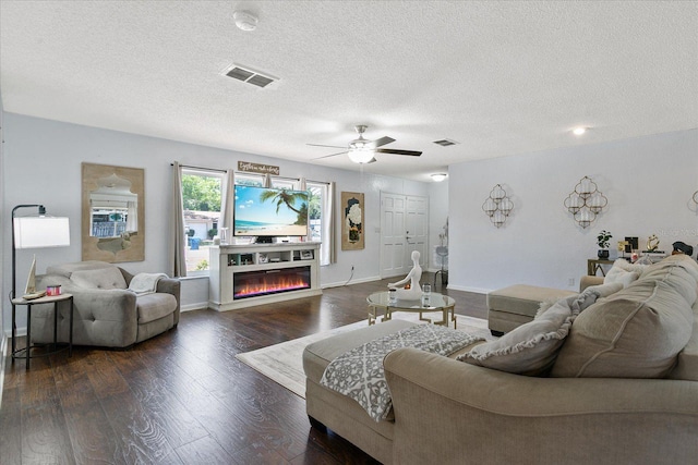 living room with ceiling fan, dark hardwood / wood-style floors, and a textured ceiling