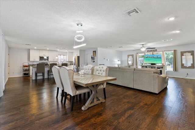 dining area featuring dark hardwood / wood-style flooring, ceiling fan, and a textured ceiling