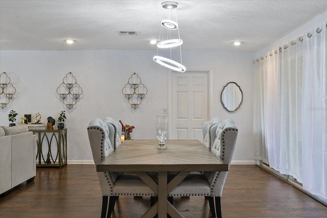 dining area with dark hardwood / wood-style floors and a textured ceiling