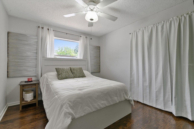 bedroom featuring dark wood-type flooring, ceiling fan, and a textured ceiling